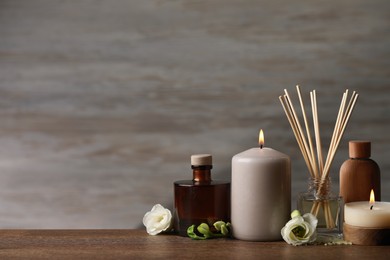 Photo of Beautiful composition with burning candles and different spa products on wooden table. Space for text