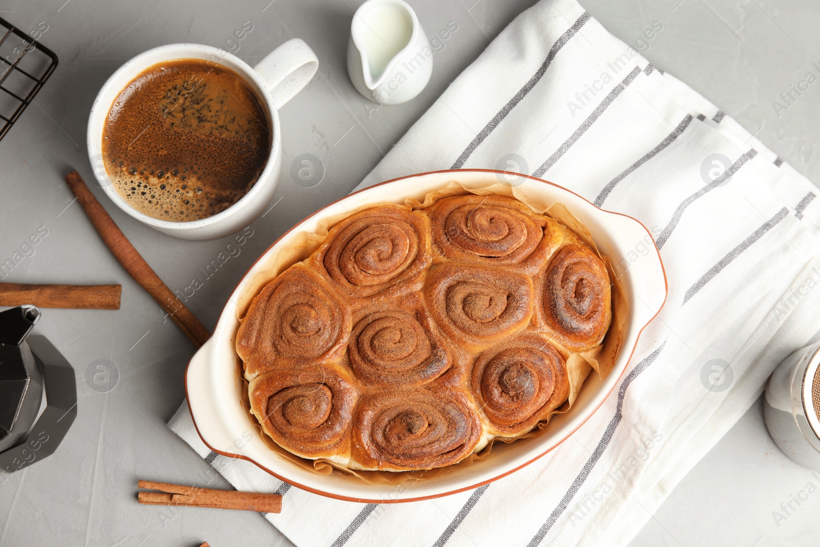 Photo of Flat lay composition with freshly baked cinnamon rolls on grey background