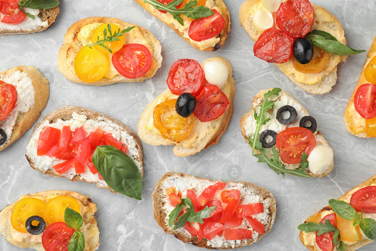 Photo of Delicious tomato bruschettas on light grey marble background, flat lay