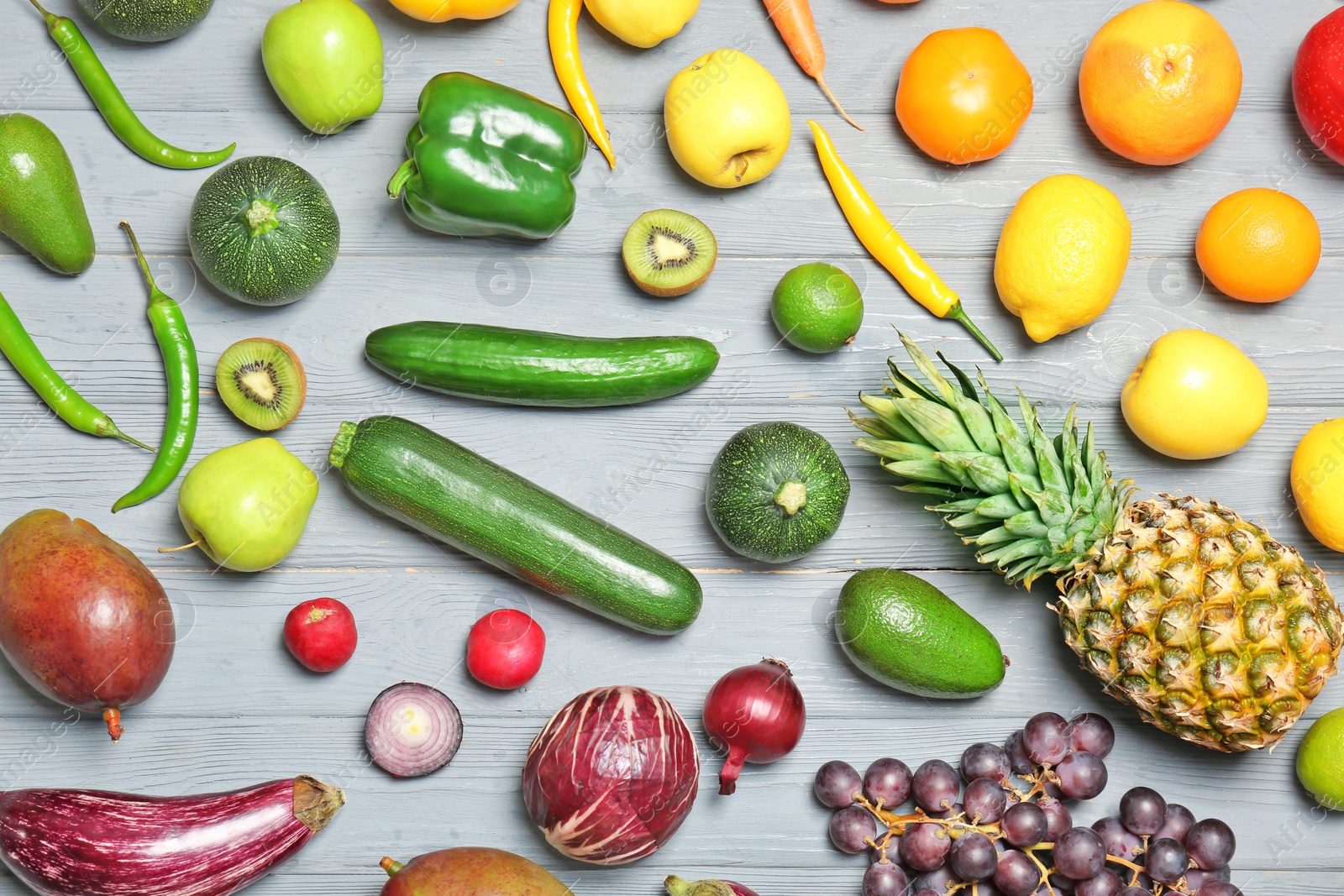 Photo of Rainbow collection of ripe fruits and vegetables on grey background, top view