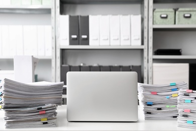 Laptop and documents on desk in office