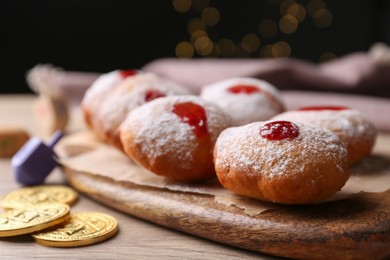 Hanukkah donuts with jelly and powdered sugar on wooden table, closeup