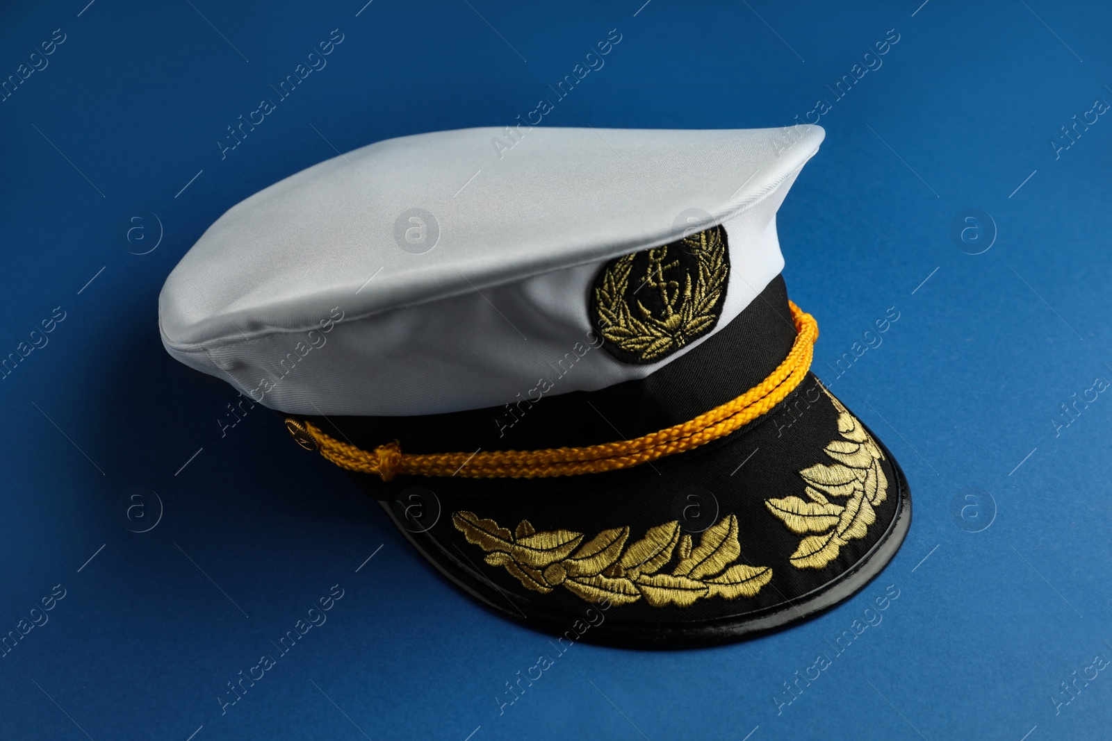 Photo of Peaked cap with accessories on blue background