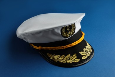 Photo of Peaked cap with accessories on blue background