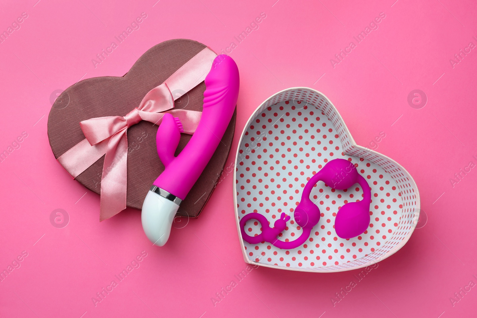Photo of Gift box with sex toys on pink background, flat lay