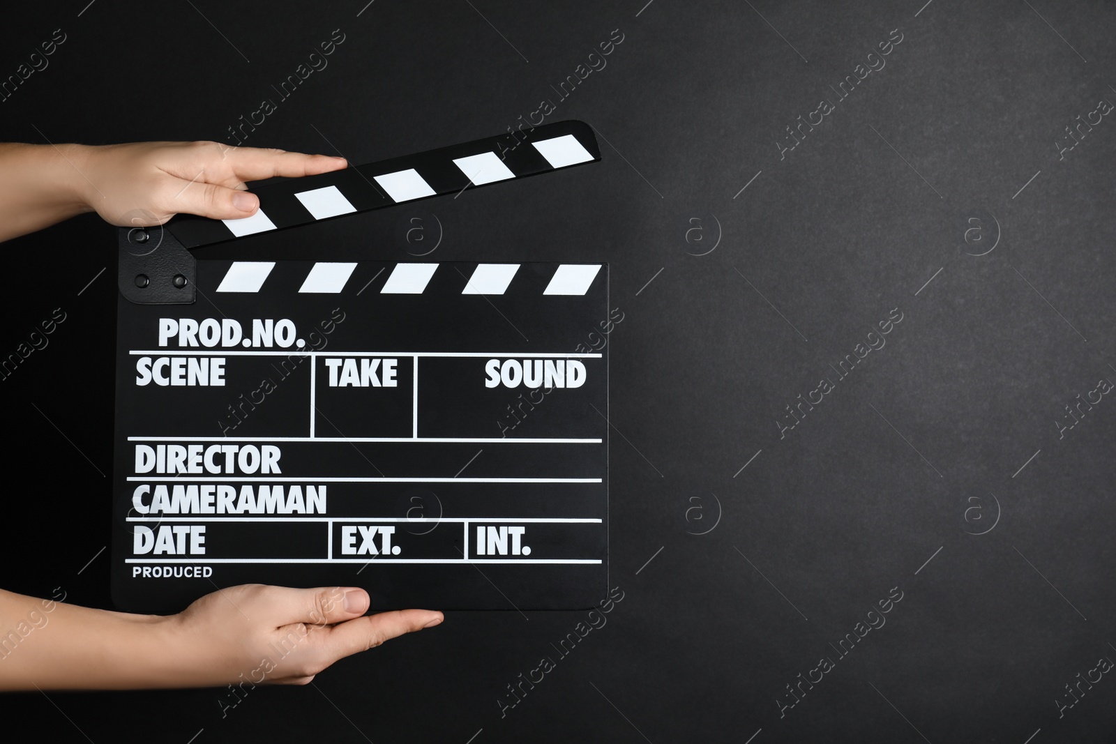 Photo of Woman holding clapperboard on black background, closeup with space for text. Cinema production