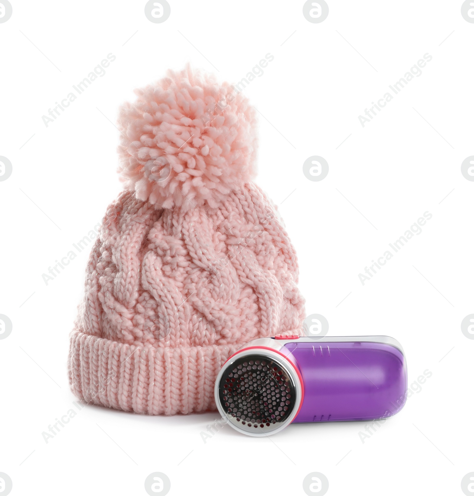 Photo of Modern fabric shaver and woolen hat on white background
