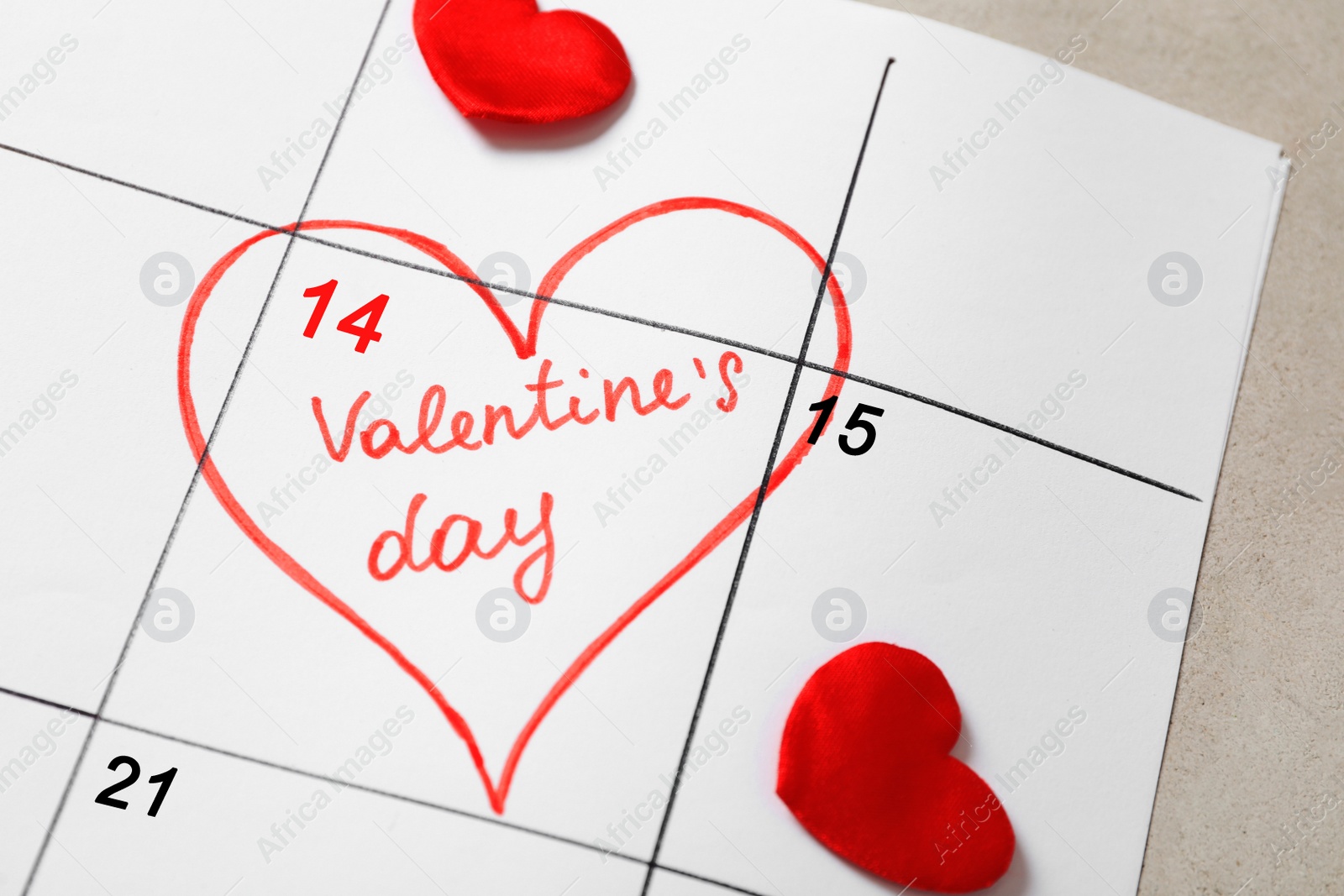 Photo of Calendar with marked Valentine's Day and hearts on grey table, closeup
