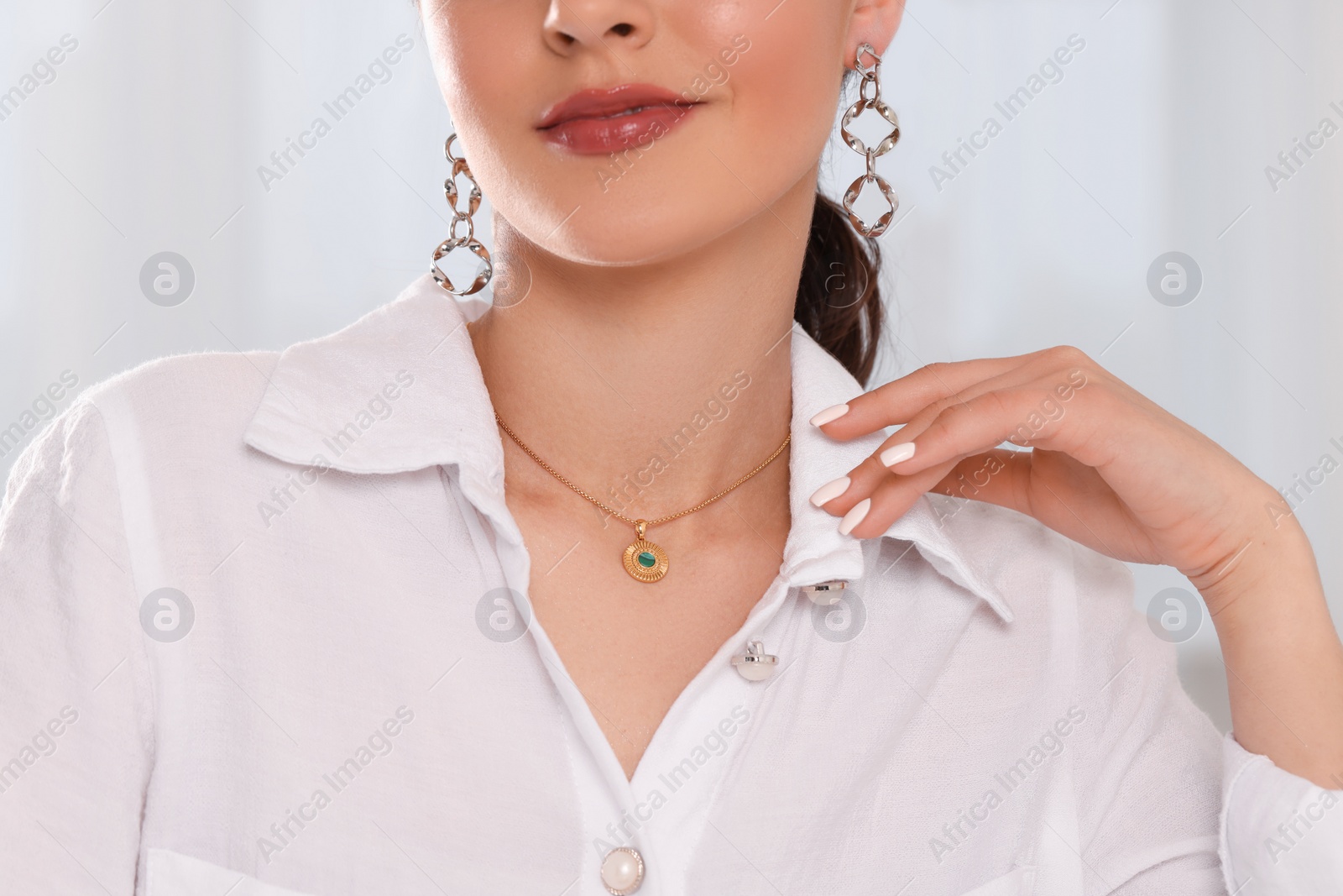 Photo of Beautiful woman with elegant jewelry on light background, closeup