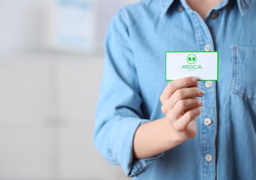 Photo of Woman holding medical business card on blurred background, closeup with space for text. Nephrology service