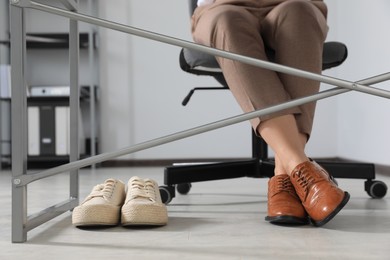 Comfortable sneakers near businesswoman in elegant shoes indoors, closeup