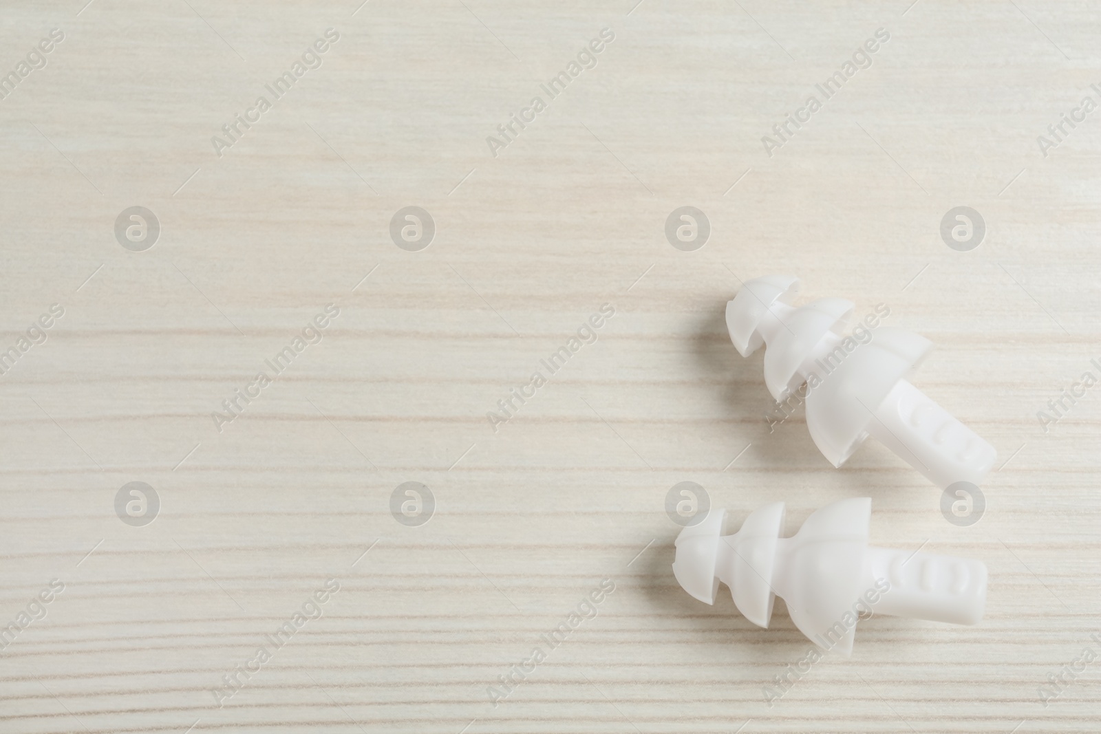 Photo of Pair of ear plugs on white wooden background, flat lay. Space for text