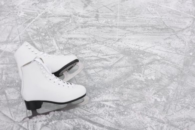 Photo of Pair of figure skates on ice, above view. Space for text