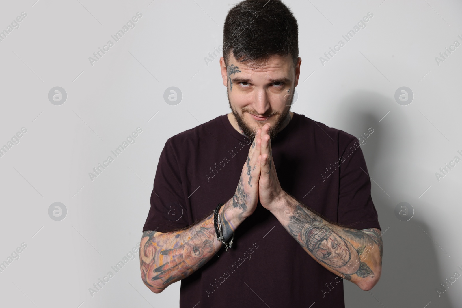 Photo of Portrait of hipster man with clasped hands on light grey background