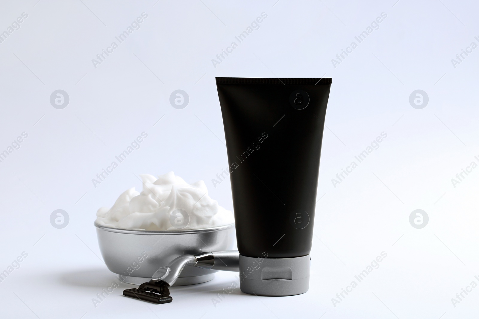 Photo of Razor and men's cosmetic products on light background