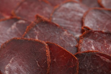 Photo of Delicious dry-cured beef basturma slices as background, closeup