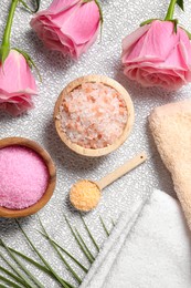 Flat lay composition with natural sea salt and beautiful roses on textured table