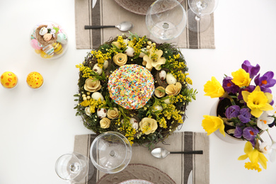 Festive Easter table setting with beautiful floral decor and eggs, flat lay