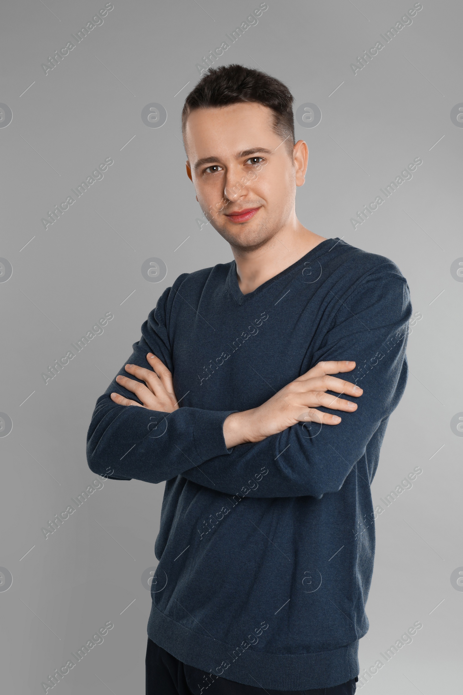 Photo of Portrait of happy young man on grey background