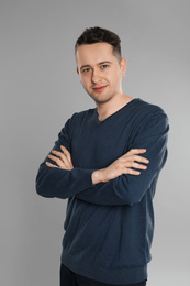 Portrait of happy young man on grey background