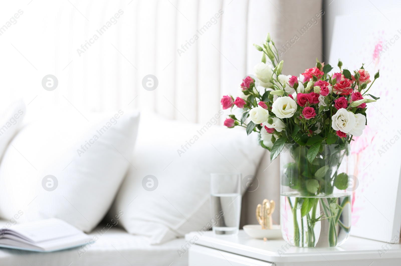 Photo of Glass vase with fresh flowers in bedroom