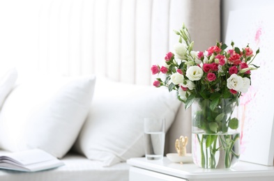 Photo of Glass vase with fresh flowers in bedroom