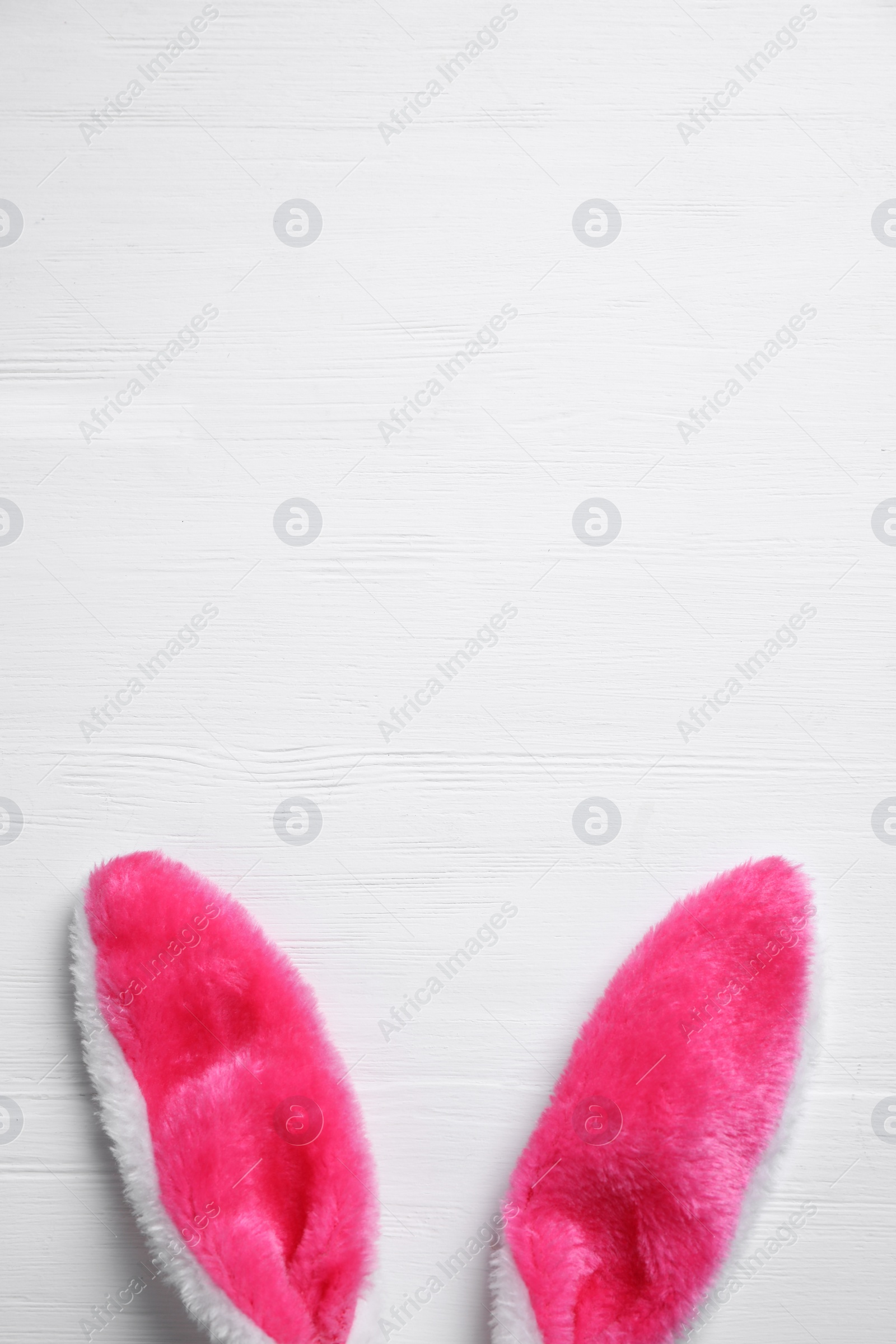 Photo of Decorative bunny ears and space for text on white wooden background, flat lay. Easter holiday