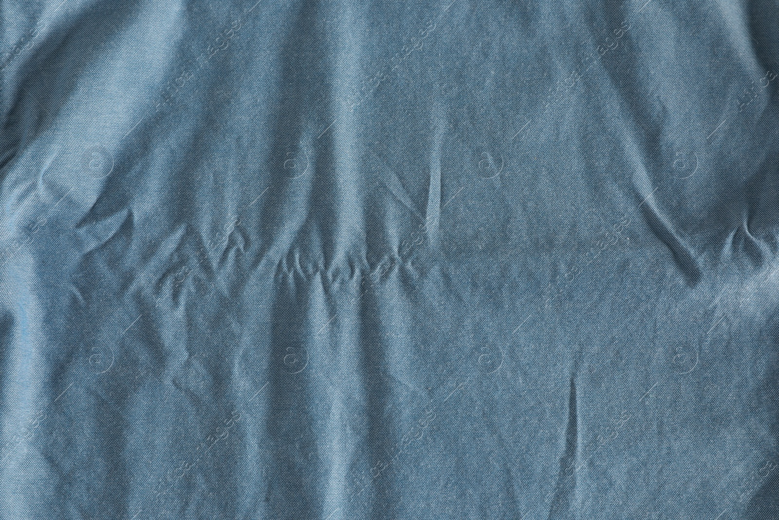 Photo of Crumpled light blue fabric as background, top view