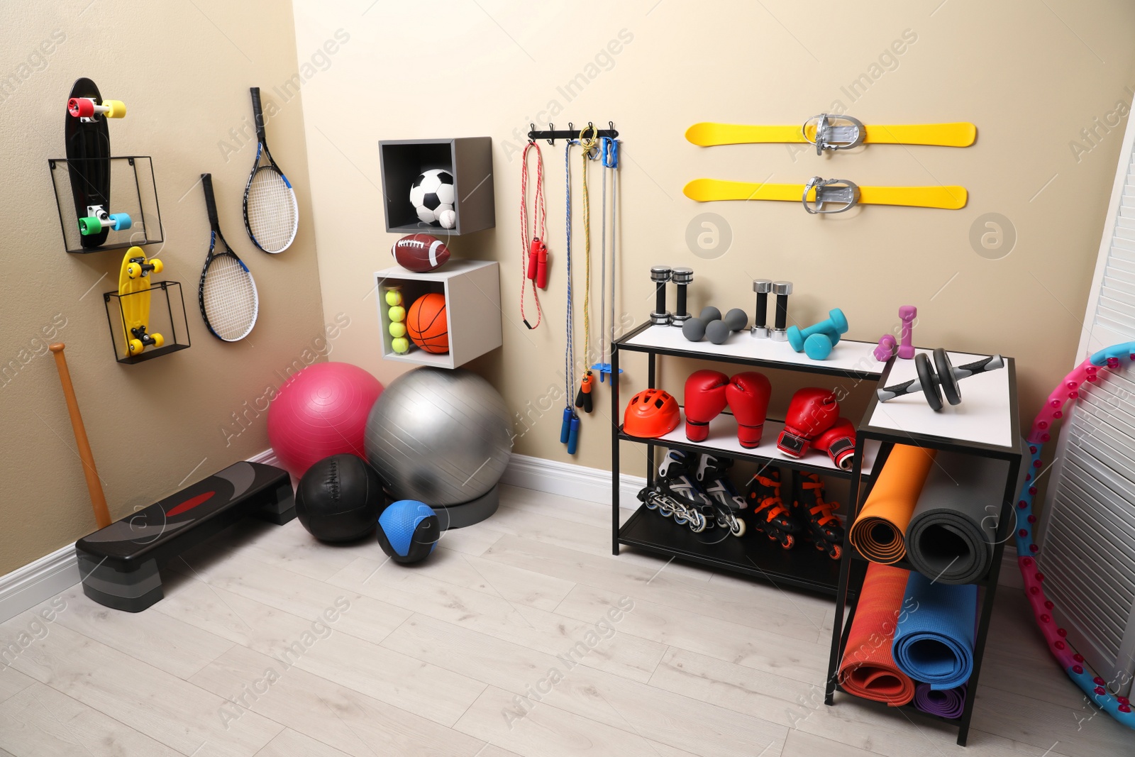 Photo of Many different sports equipment in room with beige walls