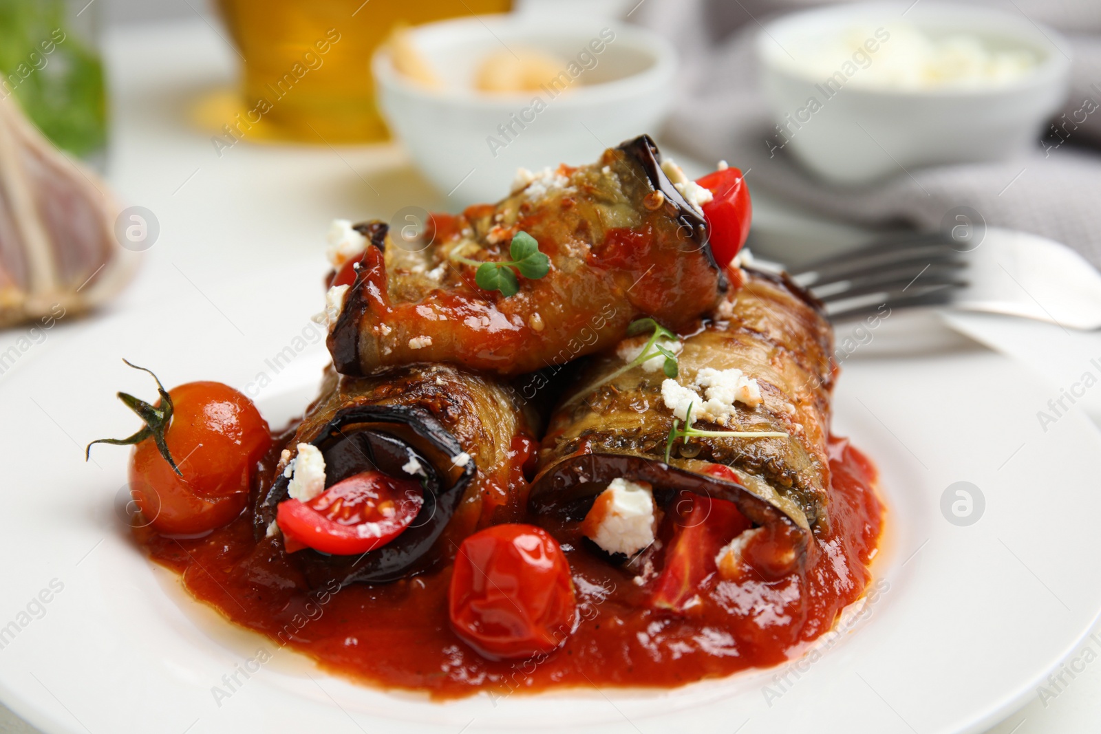 Photo of Tasty eggplant rolls served on table, closeup