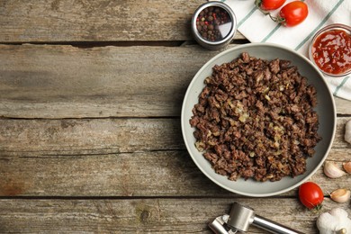 Fried minced meat and different products on wooden table, flat lay. Space for text