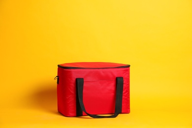 Photo of Modern red thermo bag on yellow background