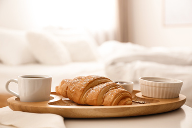 Delicious morning coffee and croissant on table indoors