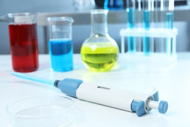 Laboratory analysis. Micropipette, petri dish and other glassware on white marble table, closeup