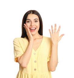 Happy young woman wearing beautiful engagement ring on white background