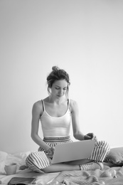 Photo of Female blogger with laptop on bed, black and white effect