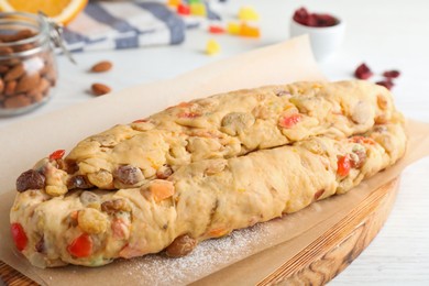 Photo of Unbaked Stollen with candied fruits and raisins on white wooden table, closeup