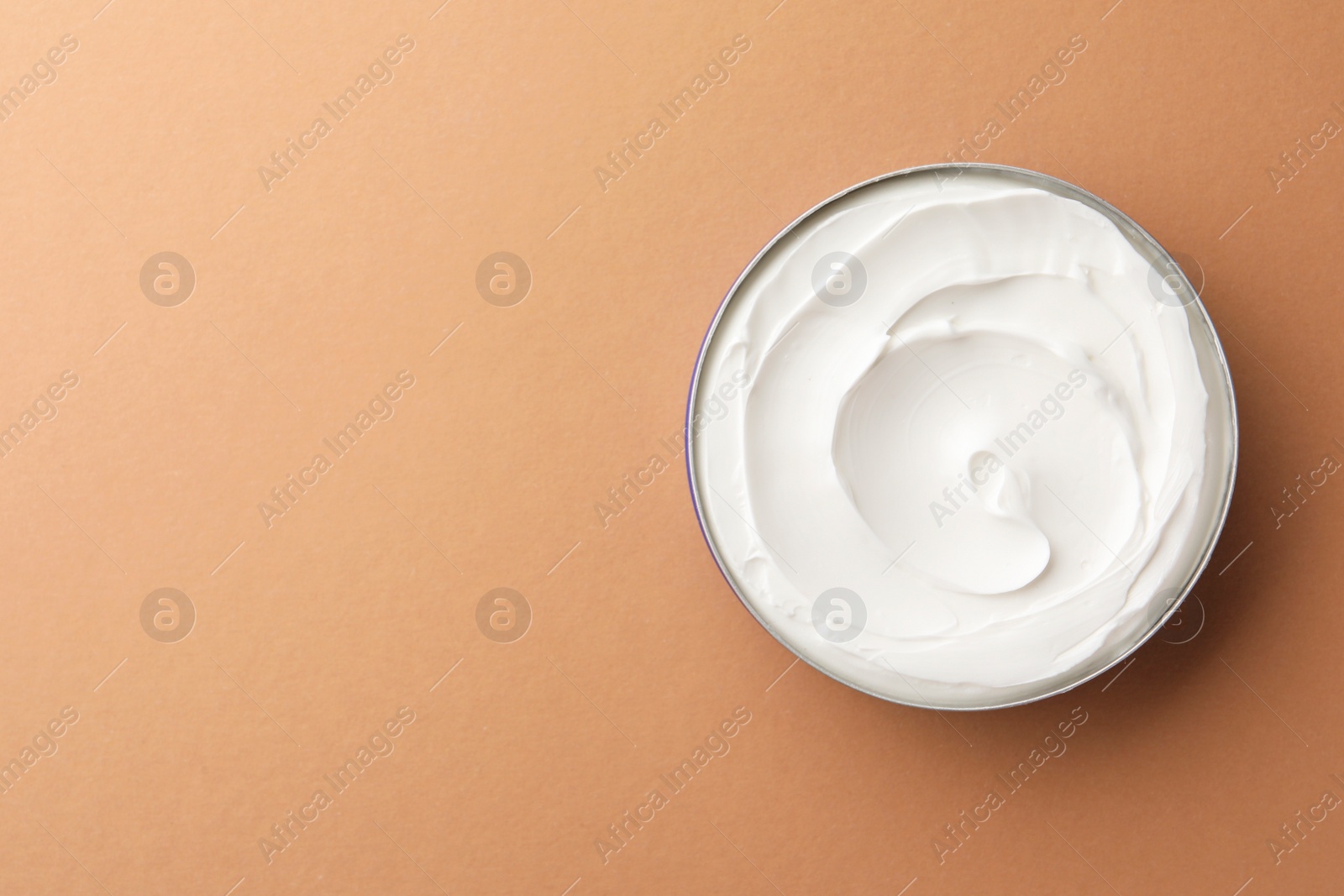 Photo of Jar of face cream on beige background, top view. Space for text