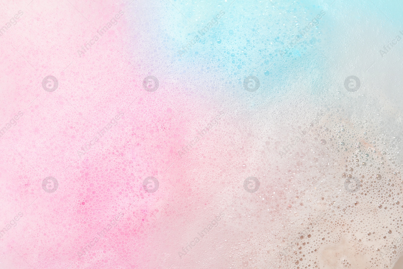 Photo of Colorful foam after dissolving bath bomb in water, closeup