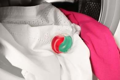 Photo of Laundry detergent capsule and clothes in washing machine