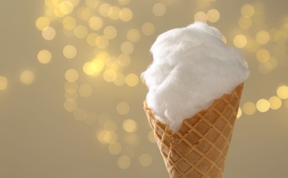 Photo of Sweet cotton candy in waffle cone against blurred lights, closeup. Space for text