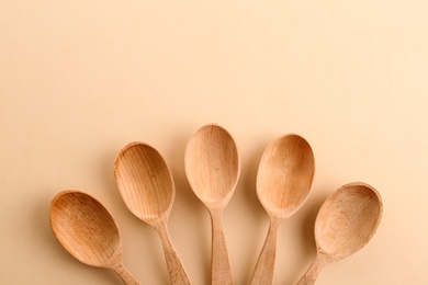 Photo of Flat lay composition with clean wooden spoons and space for text on color background