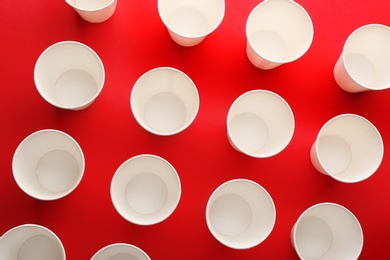 Photo of Paper cups on color background, top view. Picnic table setting