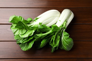 Photo of Fresh green pak choy cabbages on wooden table, flat lay