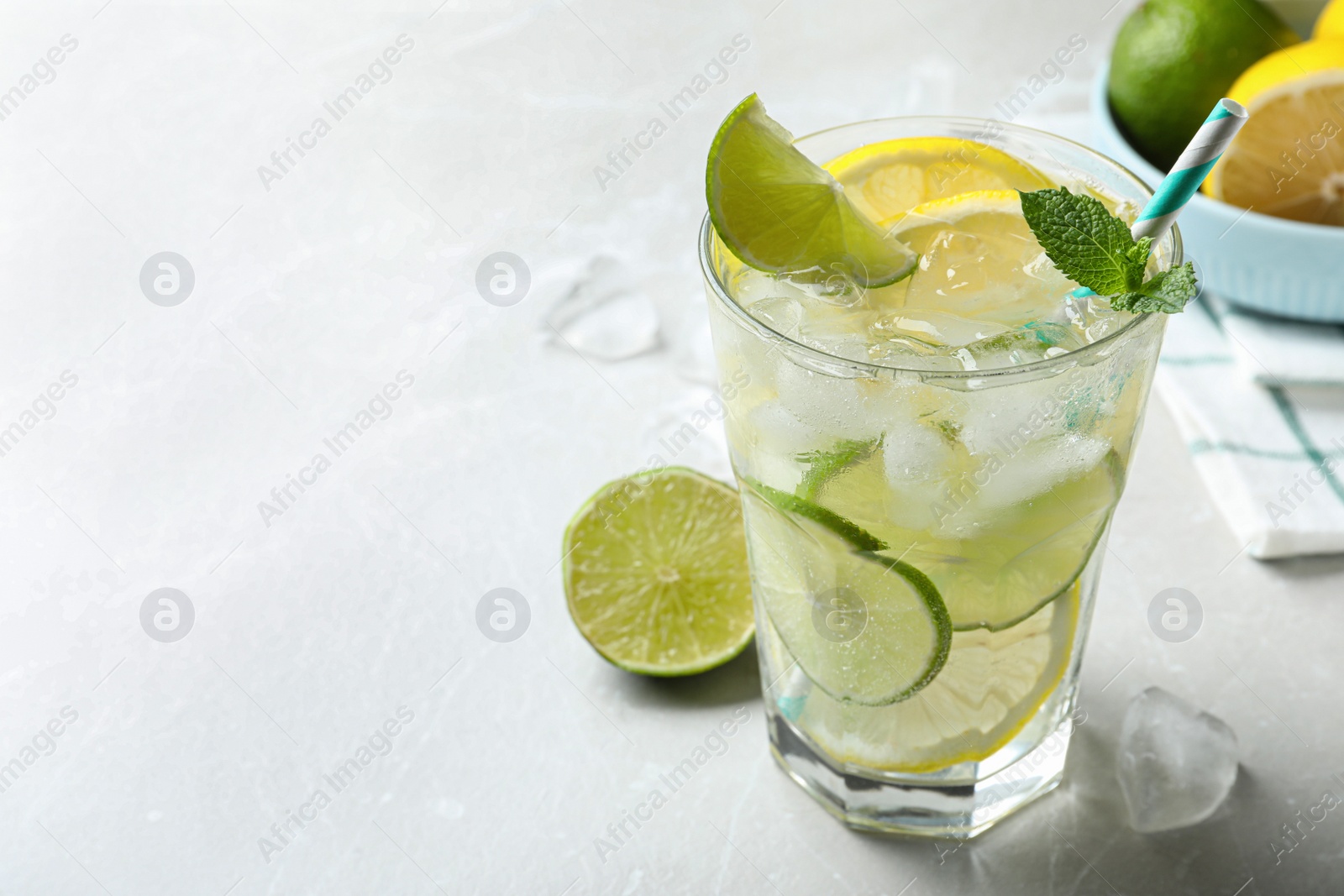 Photo of Delicious lemonade with soda water and mint on light grey table, space for text. Fresh summer cocktail