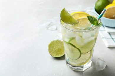 Photo of Delicious lemonade with soda water and mint on light grey table, space for text. Fresh summer cocktail