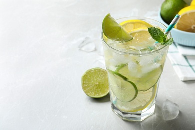 Delicious lemonade with soda water and mint on light grey table, space for text. Fresh summer cocktail