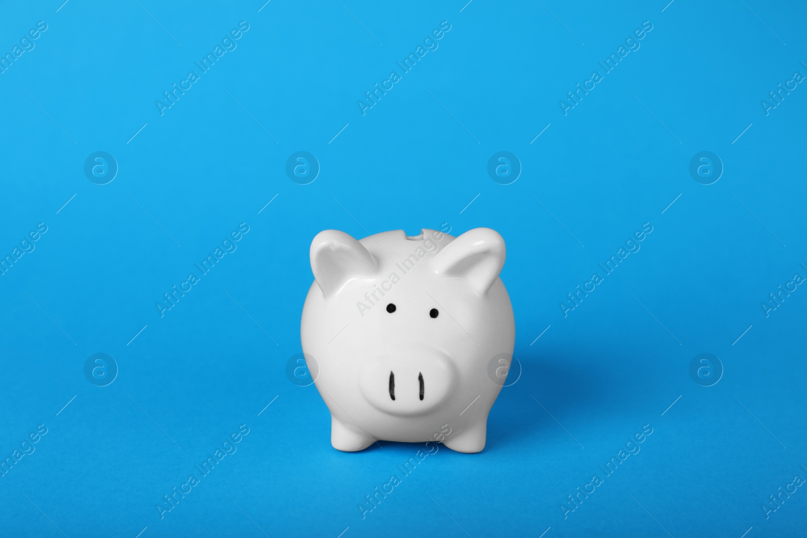 Photo of Ceramic piggy bank on light blue background. Financial savings