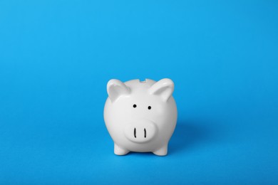 Photo of Ceramic piggy bank on light blue background. Financial savings