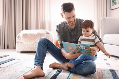 Dad and his son reading book at home